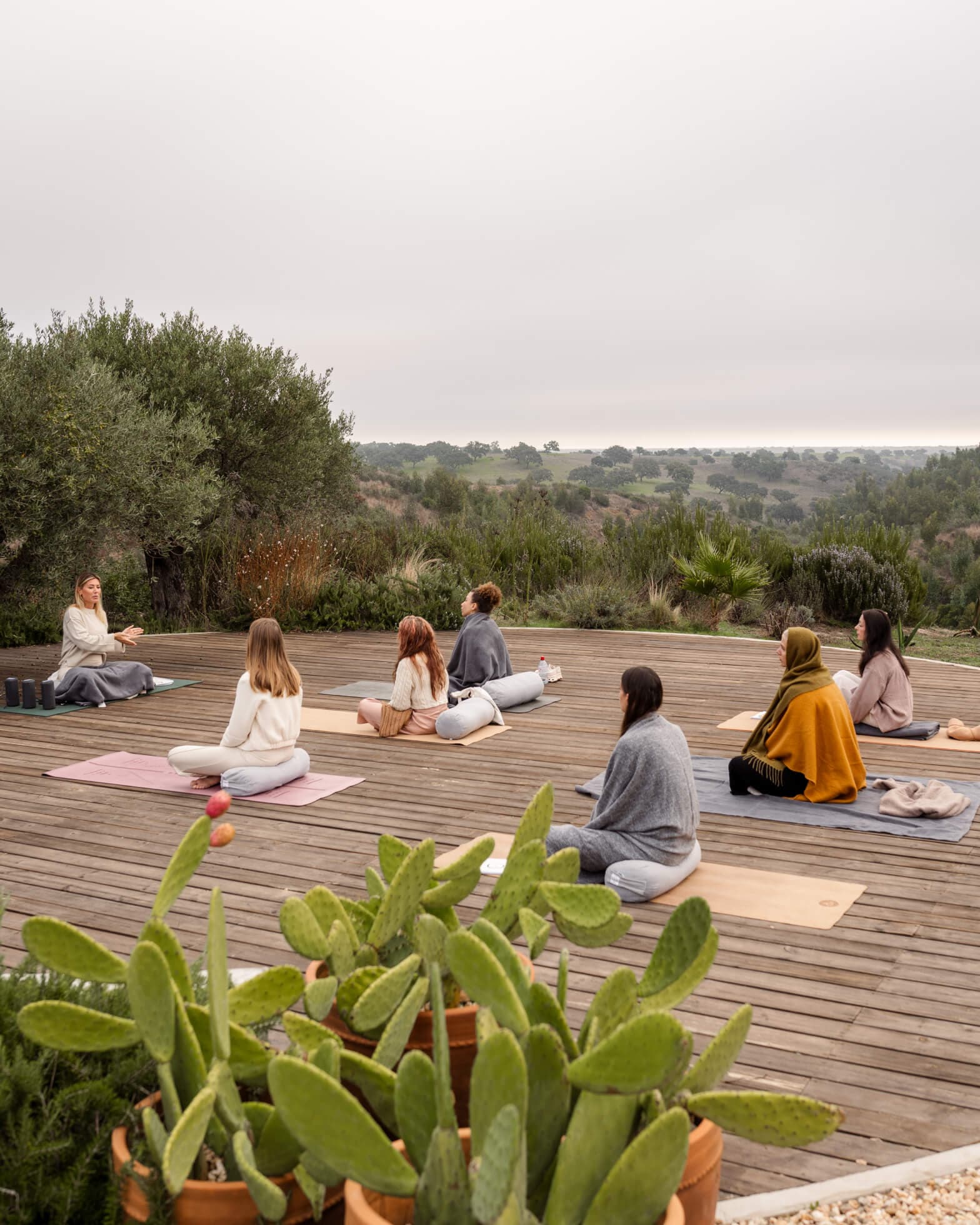 Distant photo of 7 women on decking during a Kundalini class